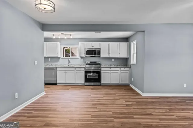 a kitchen with stainless steel appliances granite countertop a sink a stove a microwave and cabinets