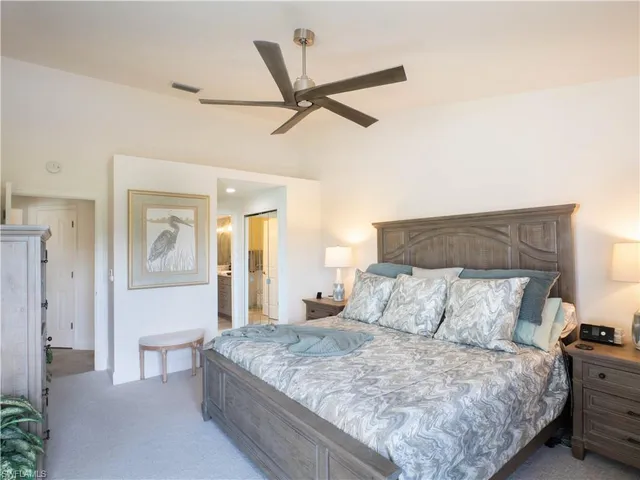 a bedroom with a large bed and ceiling fan