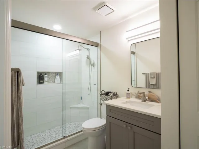 a bathroom with a granite countertop sink toilet and shower
