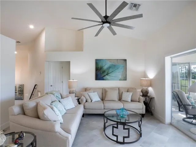 a living room with furniture a lamp and a flat screen tv