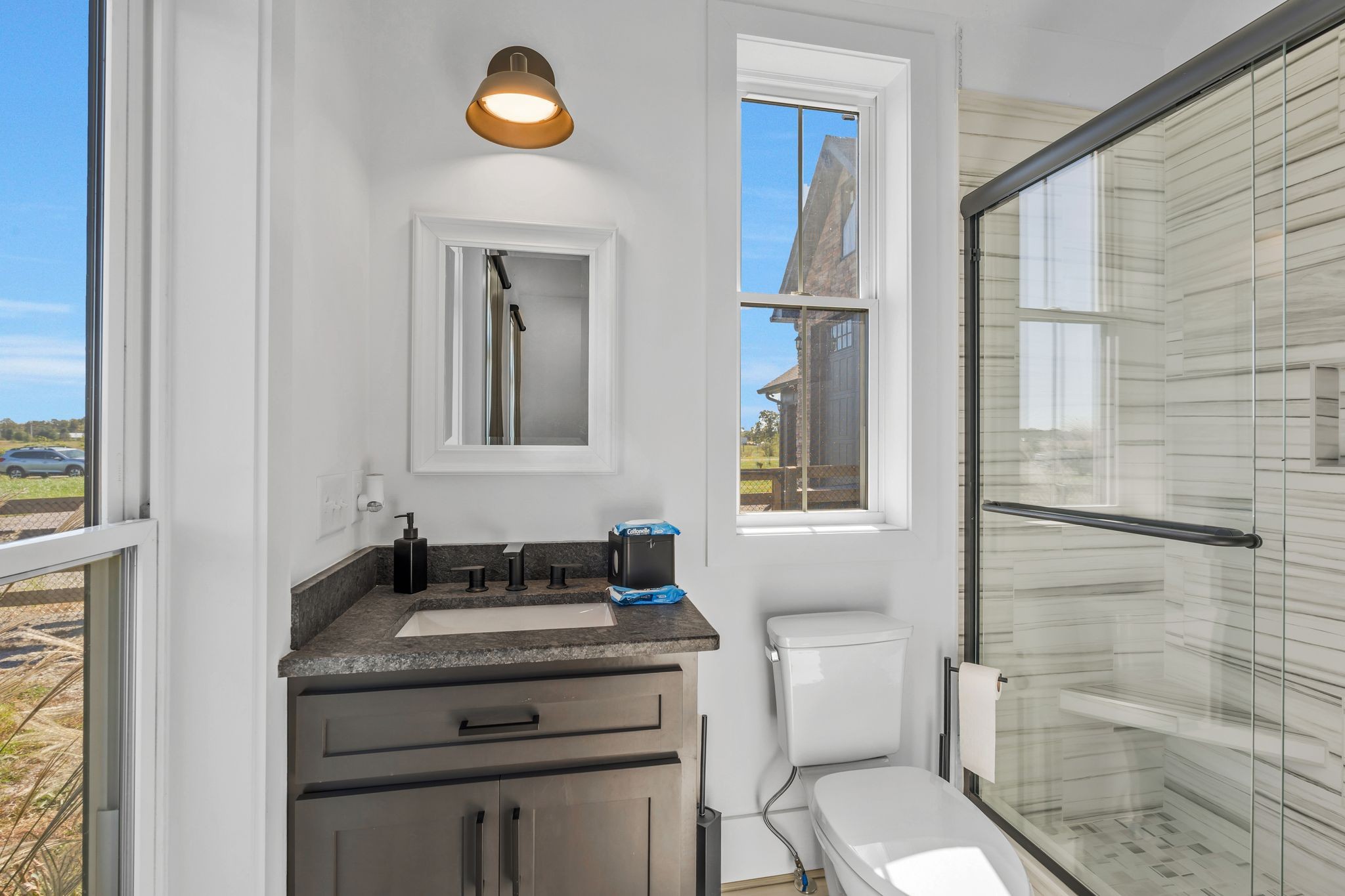 128 Emma Street Hohenwald, TN 38462 - Photo 37 of 96 a bathroom with a granite countertop sink a toilet and a mirror