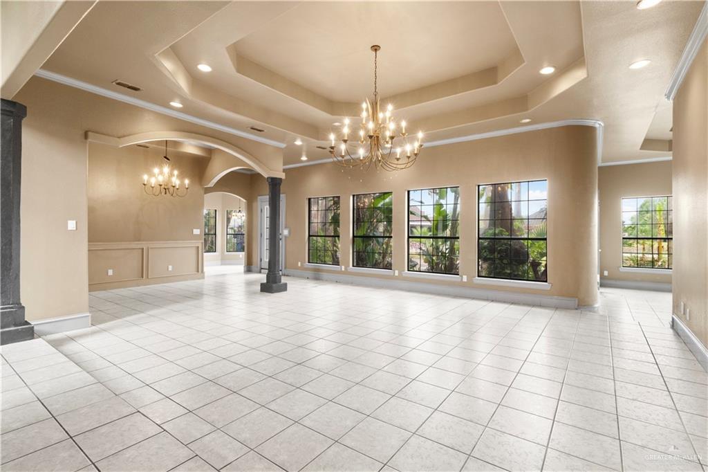 2107 South Victoria Road Donna, TX 78537 - Photo 3 of 25 Unfurnished living room with ornamental molding, a chandelier, plenty of natural light, light tile patterned floors, and recessed lighting