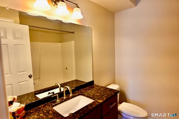 a bathroom with a granite countertop sink and a mirror