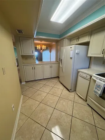 a kitchen with a refrigerator and white cabinets