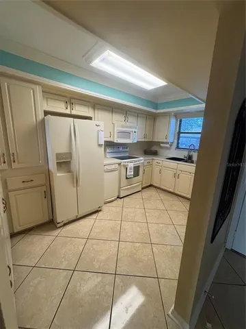 a kitchen with a refrigerator sink and cabinets