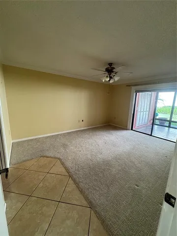 an empty room with a ceiling fan and window