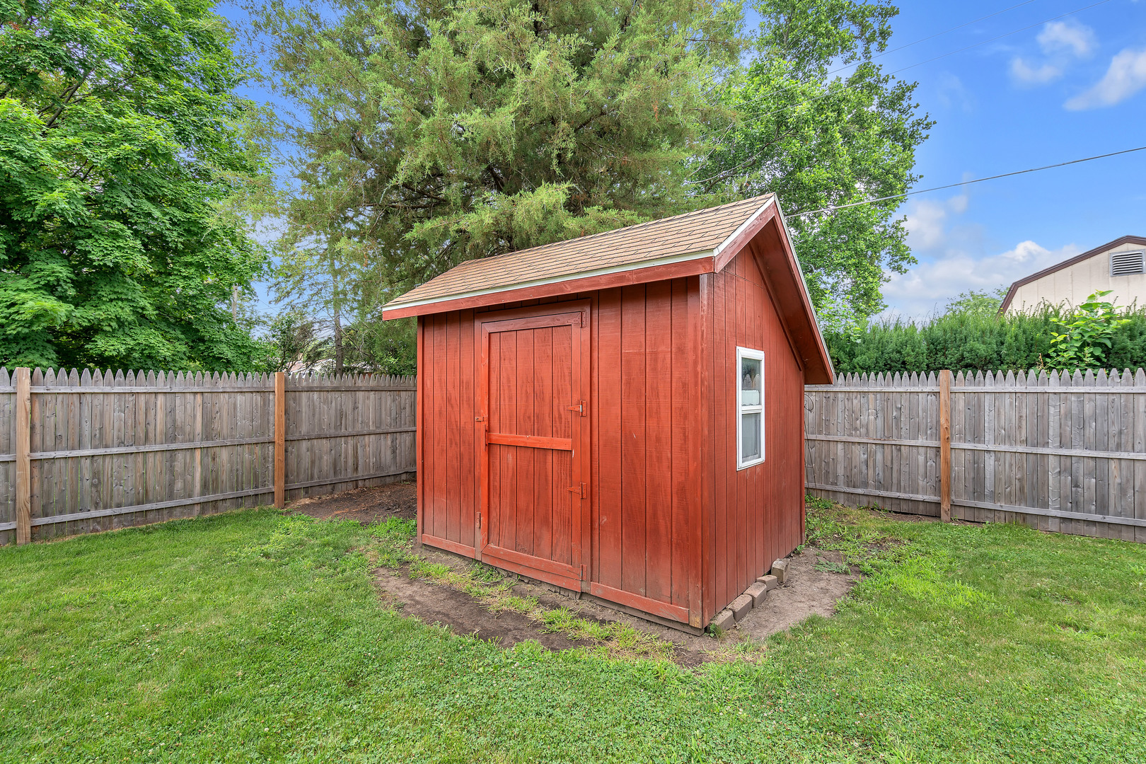 312 Wilmac Street Dwight, IL 60420 - Photo 19 of 26 a view of backyard with small cabin and wooden fence