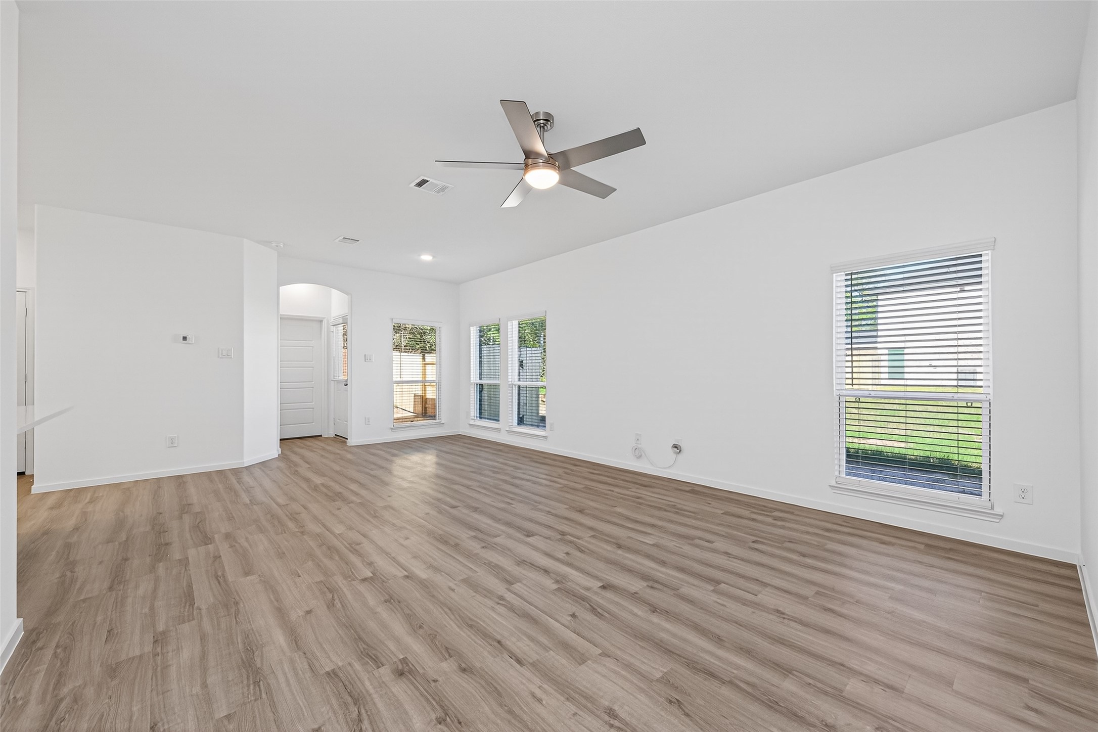 12359 Sunset Canyon Way Willis, TX 77318 - Photo 8 of 35 an empty room with wooden floor a ceiling fan white walls and windows