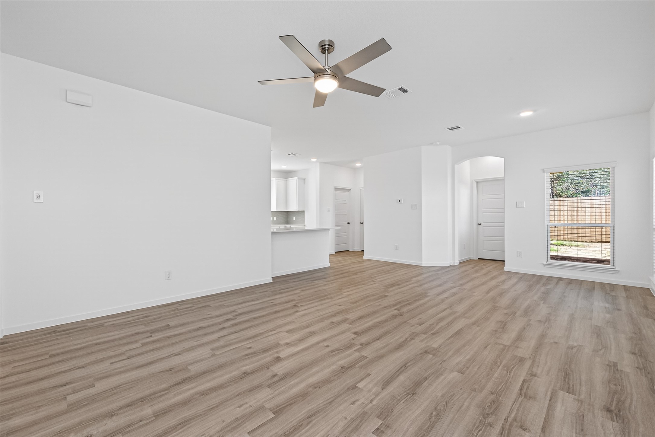 12359 Sunset Canyon Way Willis, TX 77318 - Photo 9 of 35 a view of an empty room with wooden floor and a ceiling fan