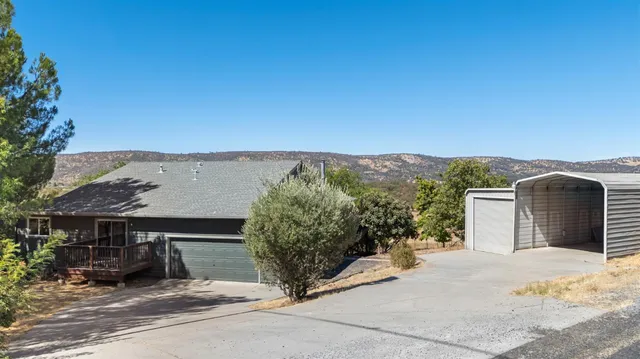 an aerial view of a houses with a yard and ocean view