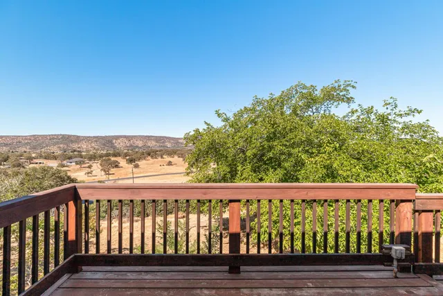 a view of a room with a chandelier fan and windows