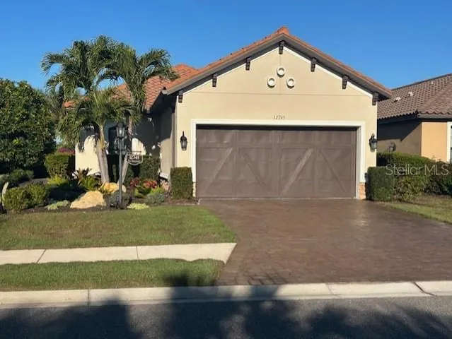 a view of a white house with a yard and garage