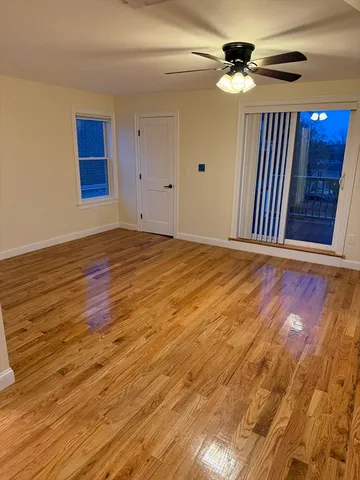 a view of a livingroom with a ceiling fan wooden floor and fan