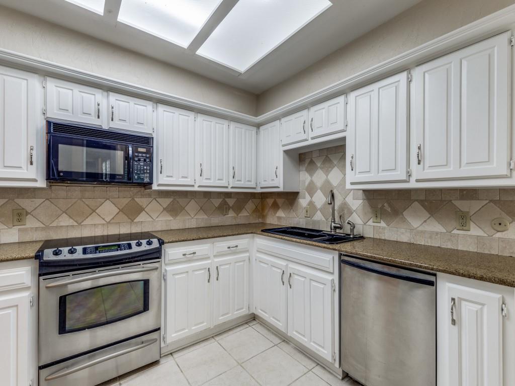 4020 Morman Lane Addison, TX 75001 - Photo 12 of 31 a kitchen with granite countertop white cabinets and stainless steel appliances