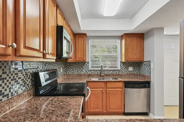 a kitchen with stainless steel appliances granite countertop a sink a stove and a microwave