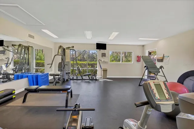 a living room with furniture gym equipment and a large window