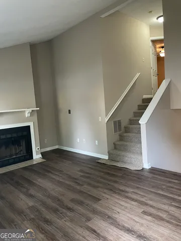a view of a livingroom with wooden floor and a fireplace