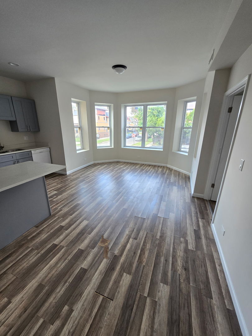 5223 West Washington Boulevard, Unit 52232 Chicago, IL 60644 - Photo 2 of 10 wooden floor in an empty room with a window