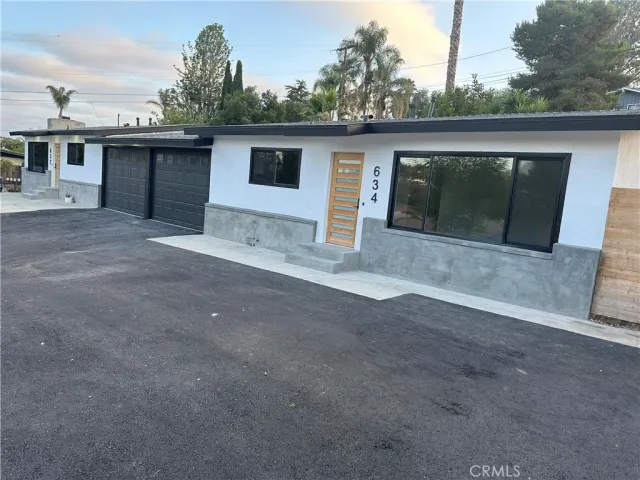 a kitchen that has a sink a stove and wooden floor