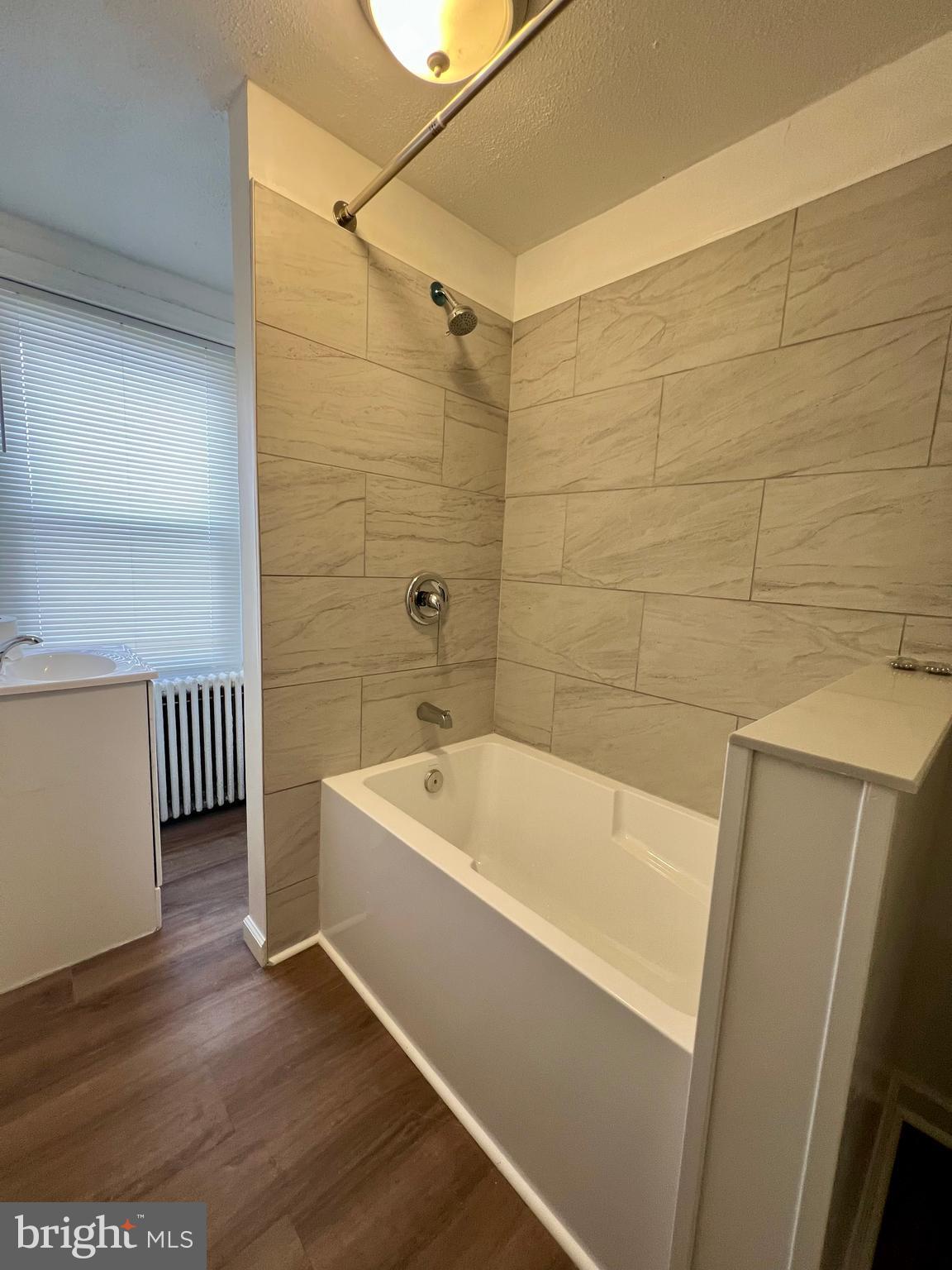 613 Walnut Street Norristown, PA 19401 - Photo 14 of 22 a bathroom with a tub a sink and wooden floor