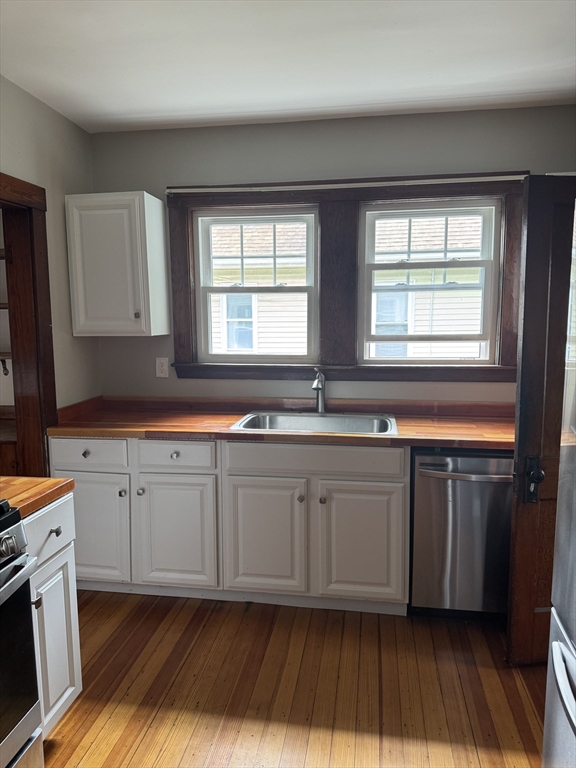 22 Allen Street, Unit 2 Arlington, MA 02474 - Photo 21 of 25 a kitchen with granite countertop cabinets stainless steel appliances a sink and a window