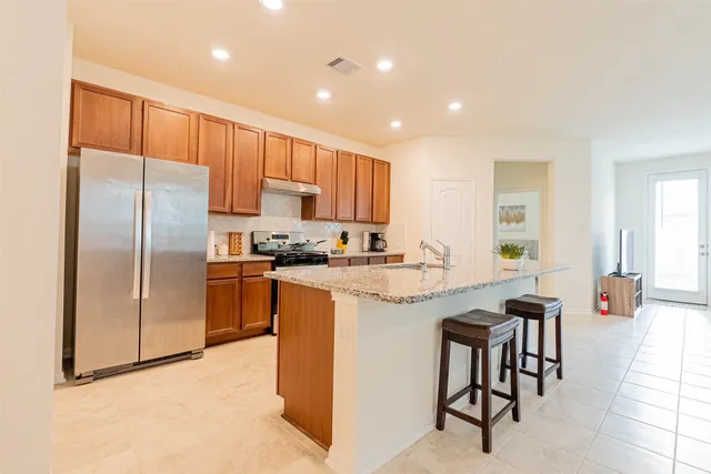 a kitchen with granite countertop white cabinets and stainless steel appliances