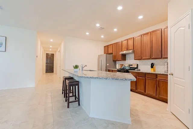 a kitchen with stainless steel appliances granite countertop a sink stove and cabinets