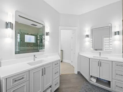 a spacious bathroom with a double vanity sink a mirror and a bathtub