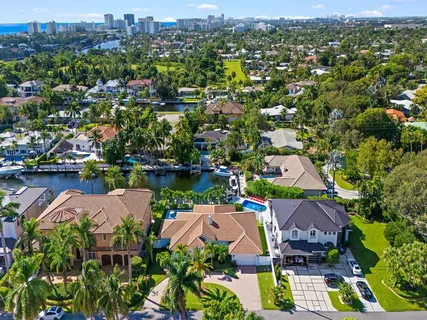 an aerial view of residential houses with outdoor space and lake view