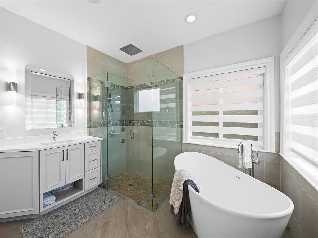 2228 Northeast 26th Street Lighthouse Point, FL 33064 - Photo 21 of 36 a spacious bathroom with a double vanity sink a mirror and a bathtub