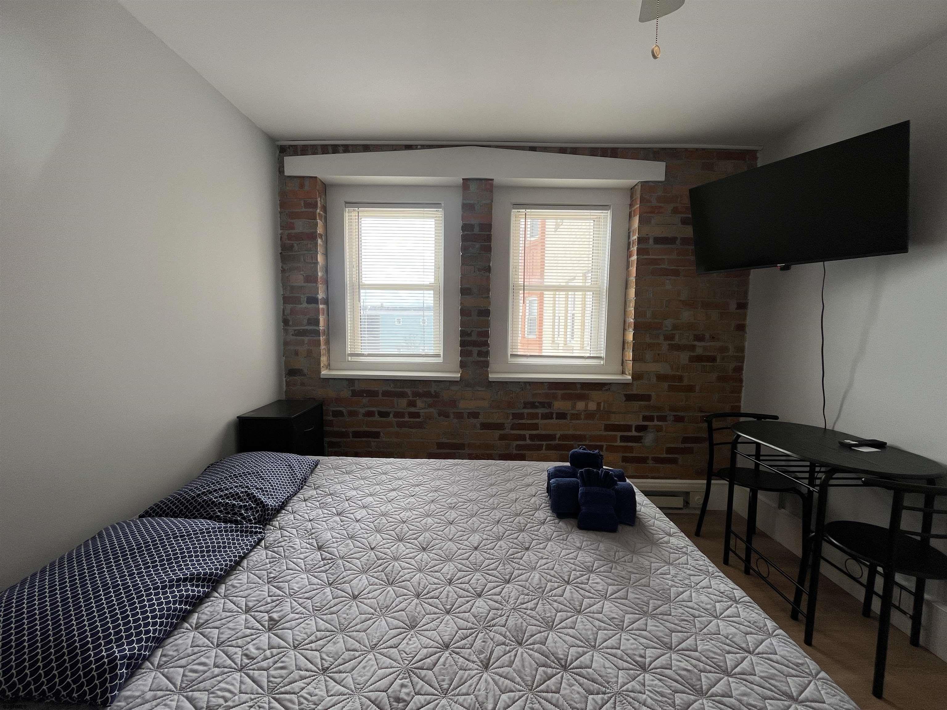 807 East 8th Street, Unit 308 Ocean City, NJ 08226 - Photo 4 of 9 a bedroom with a bed and a flat screen tv