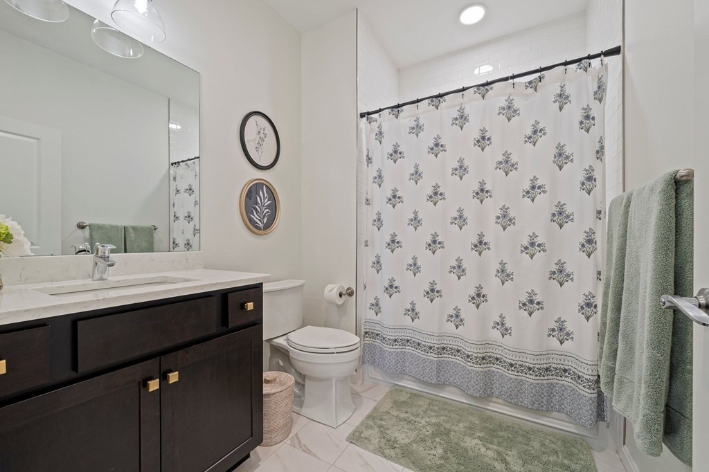 200 Revere Street, Unit 4103 Canton, MA 02021 - Photo 17 of 39 a bathroom with a granite countertop toilet sink and a mirror