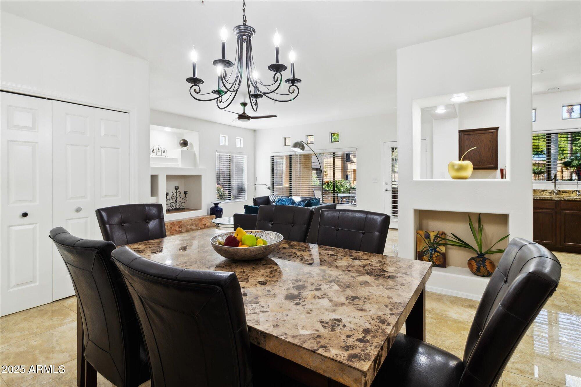 9100 East Raintree Drive, Unit 130 Scottsdale, AZ 85260 - Photo 12 of 17 a view of a dining room with furniture a chandelier and wooden floor