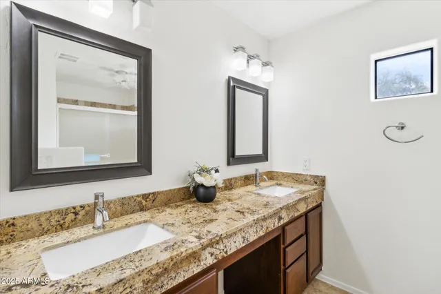 a bathroom with a granite countertop sink and a mirror