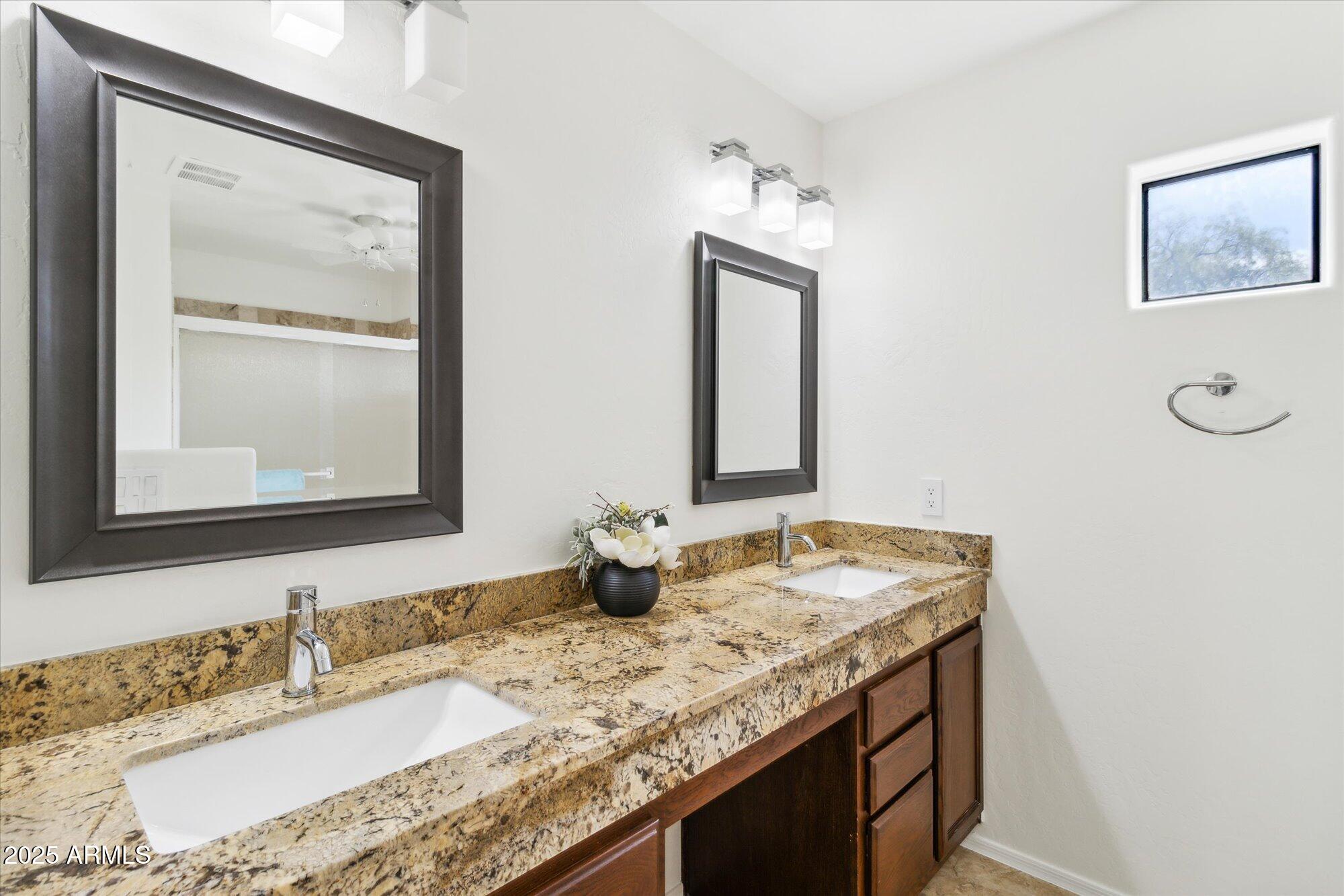 9100 East Raintree Drive, Unit 130 Scottsdale, AZ 85260 - Photo 15 of 17 a bathroom with a granite countertop sink and a mirror