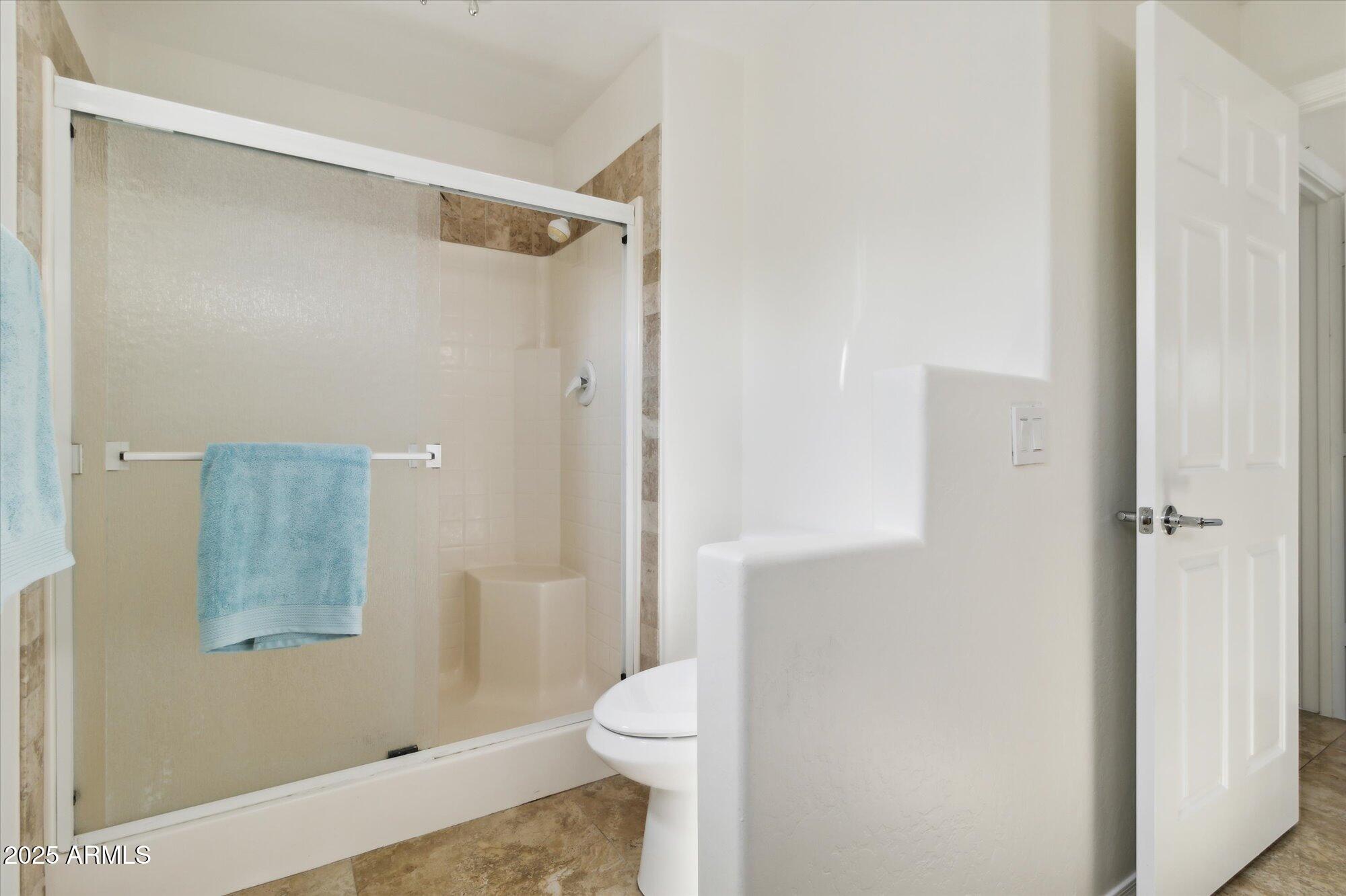 9100 East Raintree Drive, Unit 130 Scottsdale, AZ 85260 - Photo 16 of 17 a bathroom with a granite countertop shower and a toilet