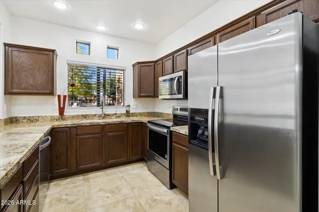 a kitchen with stainless steel appliances granite countertop a refrigerator and a sink
