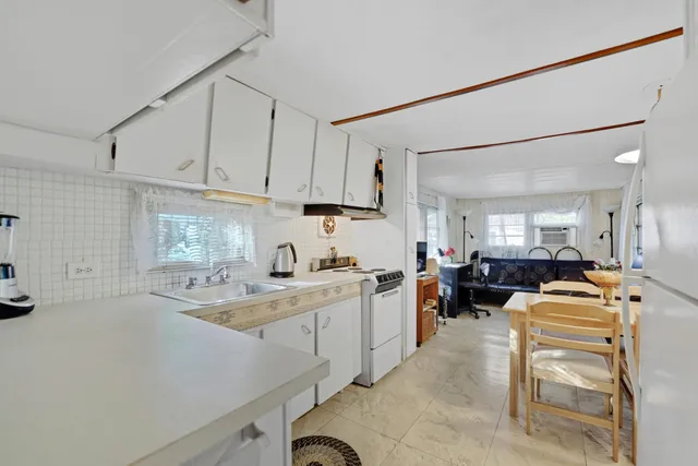 a kitchen with a sink a stove and chairs