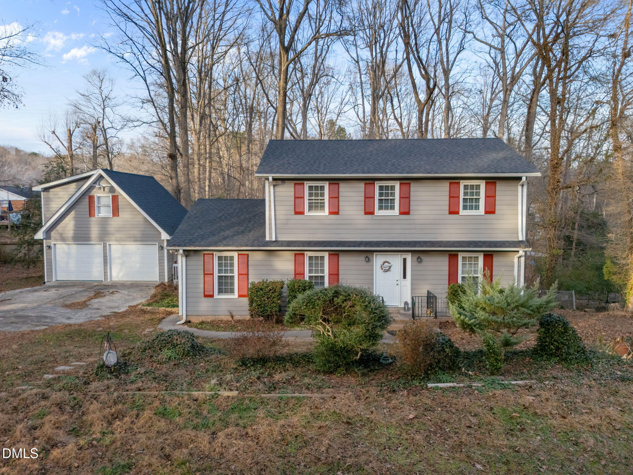 a view of a house with a yard and large trees
