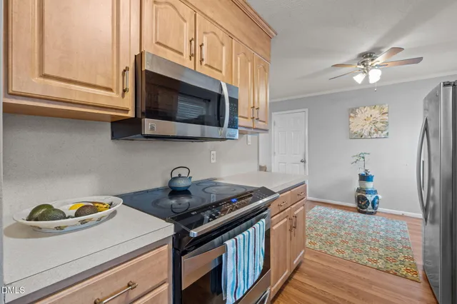 a kitchen with stainless steel appliances granite countertop a refrigerator a stove and a wooden floors