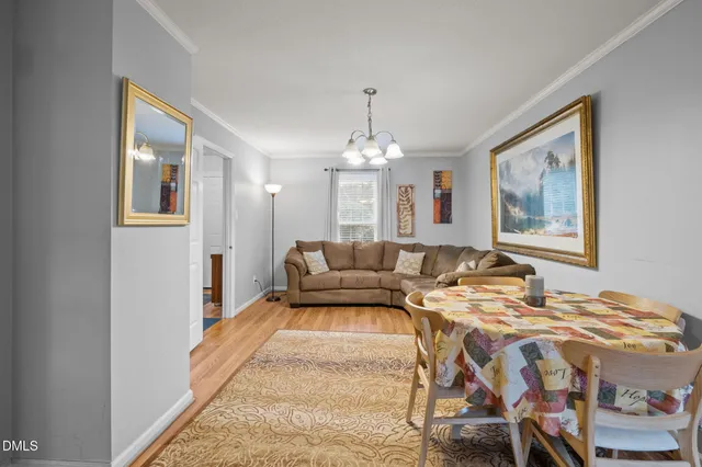 a living room with furniture a chandelier and a painting