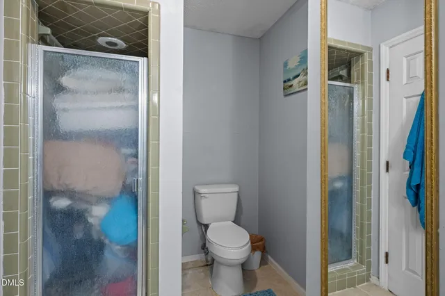 an empty room with windows and chandelier fan