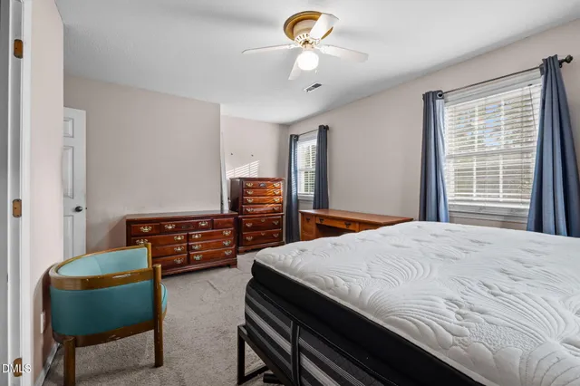 a view of a large white house with a yard and large trees