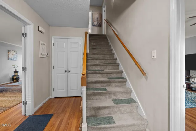 a view of a hallway with wooden floor and windows