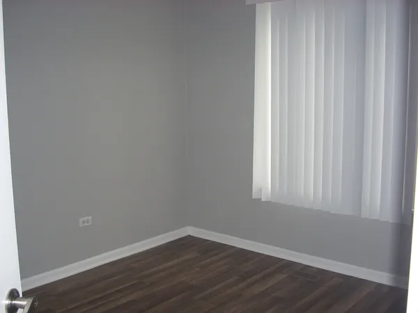 a view of a small space with wooden floor and a window
