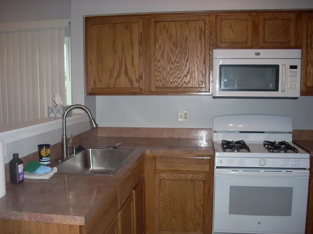 a kitchen with stainless steel appliances granite countertop a sink and a microwave