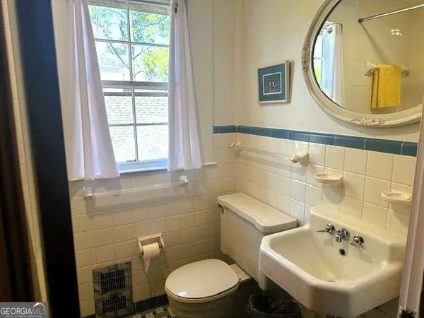 a bathroom with a sink a mirror and toilet