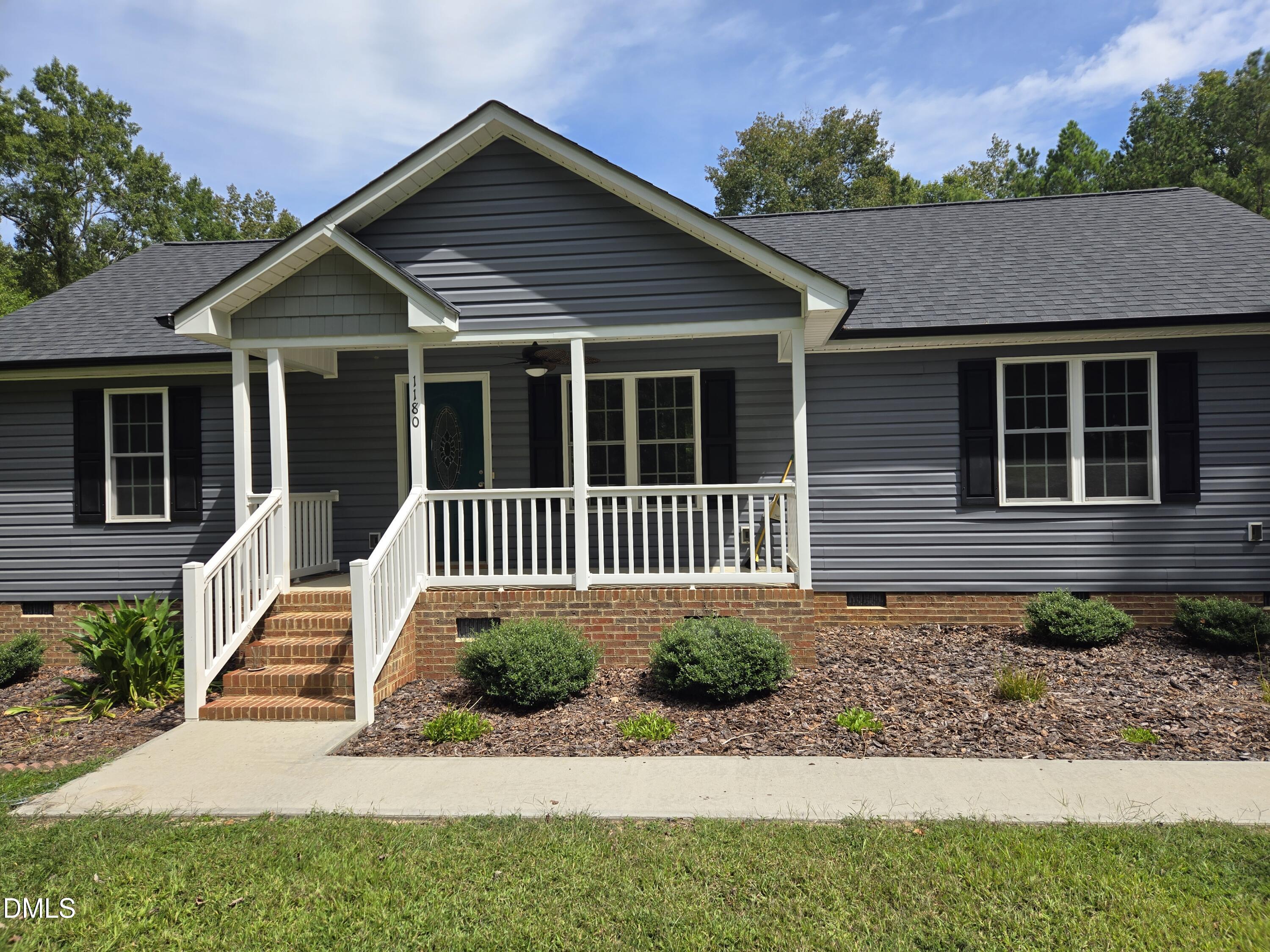 a view of a house with a small yard and wooden floor and fence