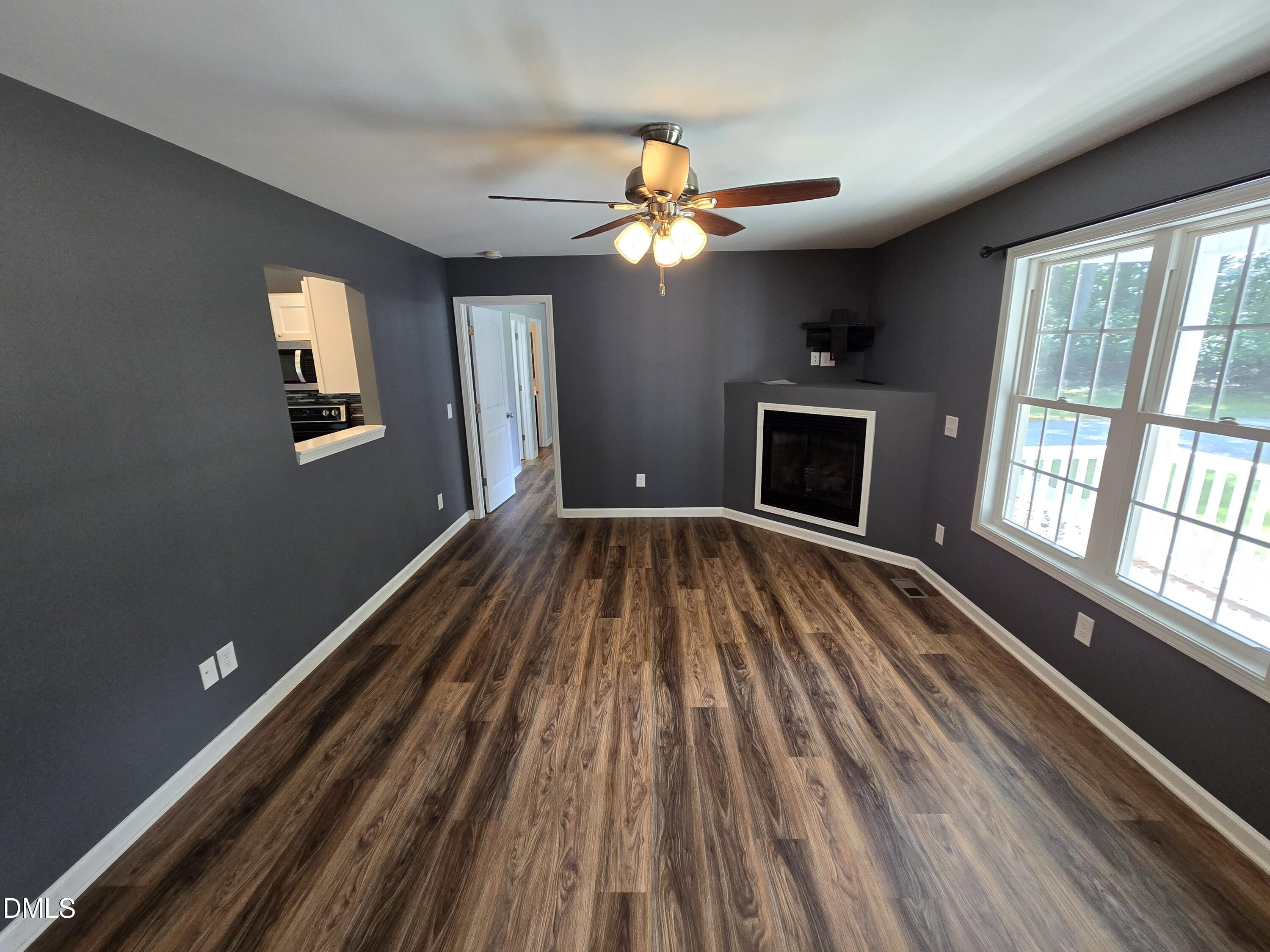 1180 Lambert Chapel Road Siler City, NC 27344 - Photo 20 of 42 a view of a livingroom with wooden floor and a ceiling fan