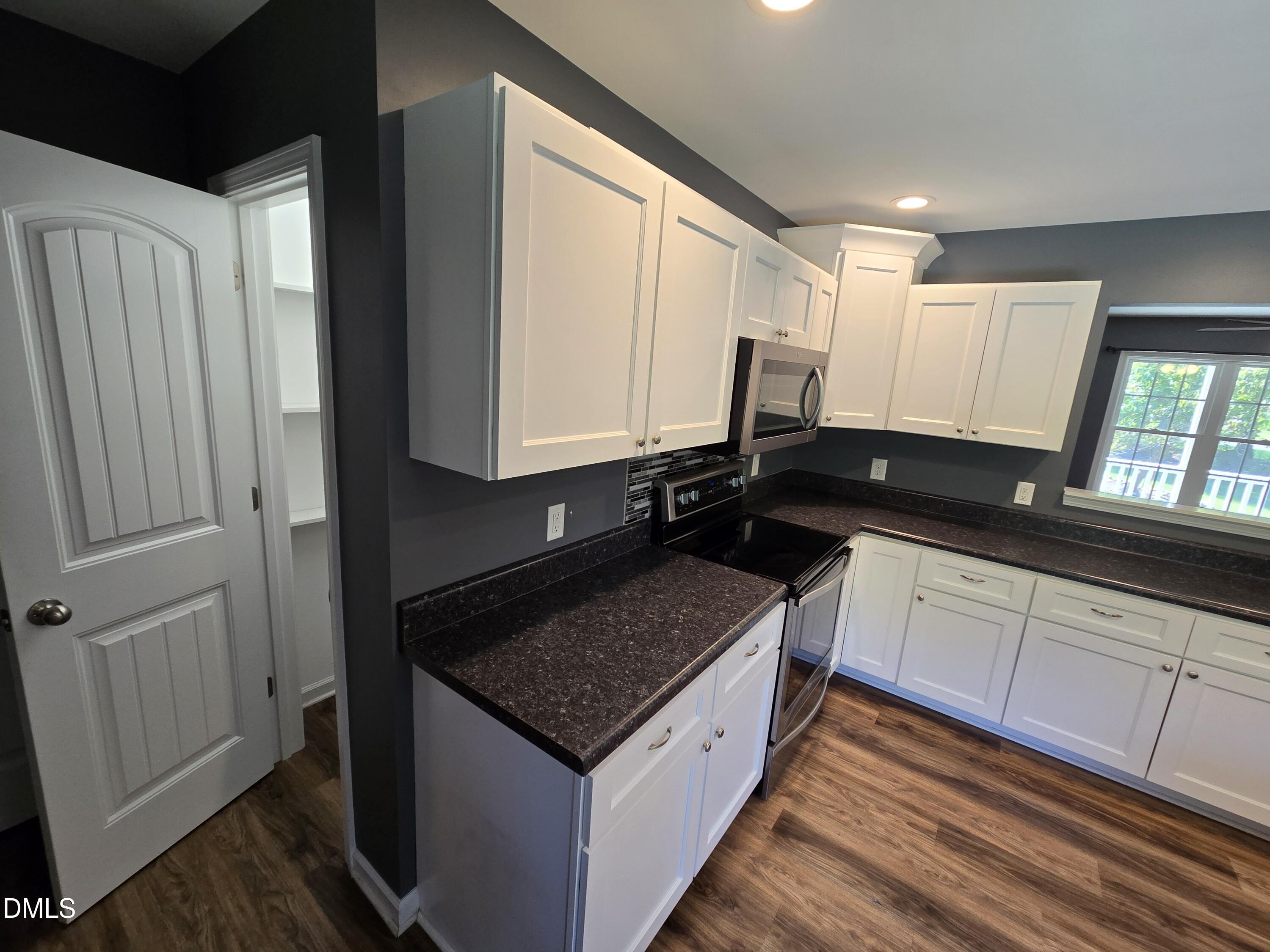 1180 Lambert Chapel Road Siler City, NC 27344 - Photo 28 of 42 a view of a sink and dishwasher with wooden floor